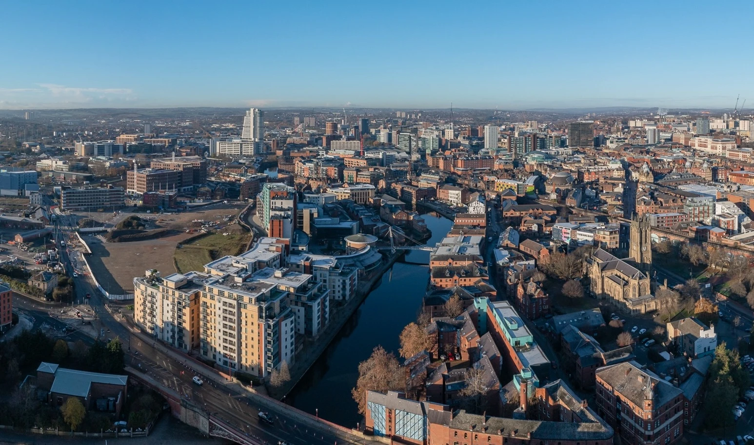 A drone shot on a clear day shows the city of Leeds, Few and Far are located near the canal shown