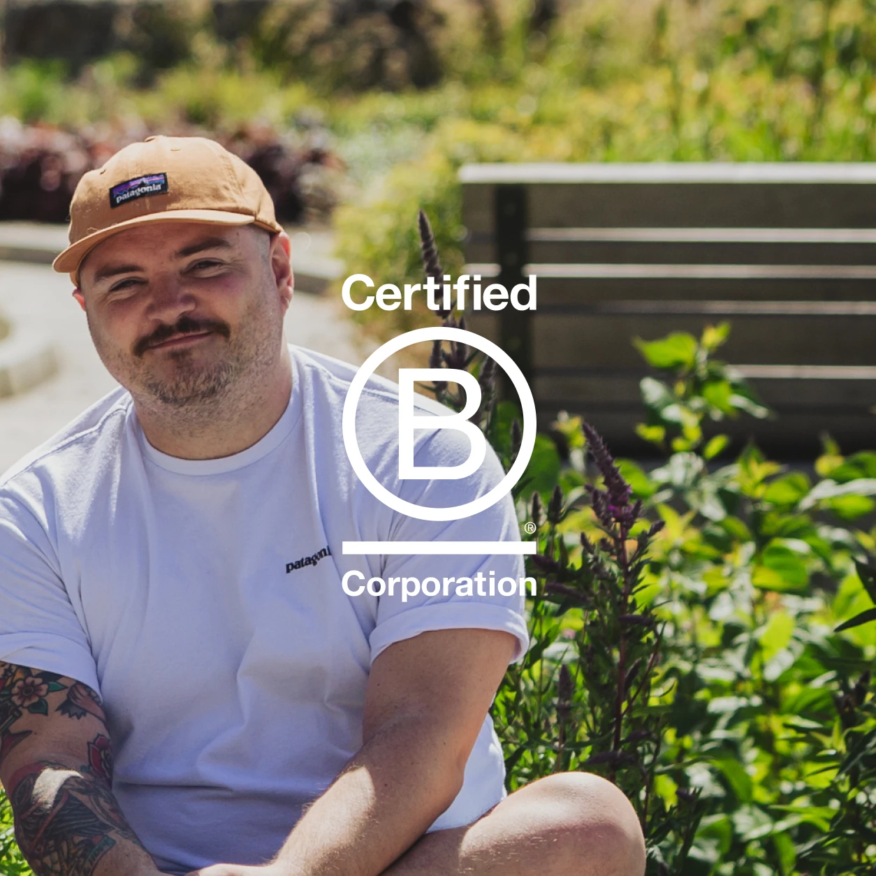 Col is sat smiling outside with the Certified B Corporation logo overlaid