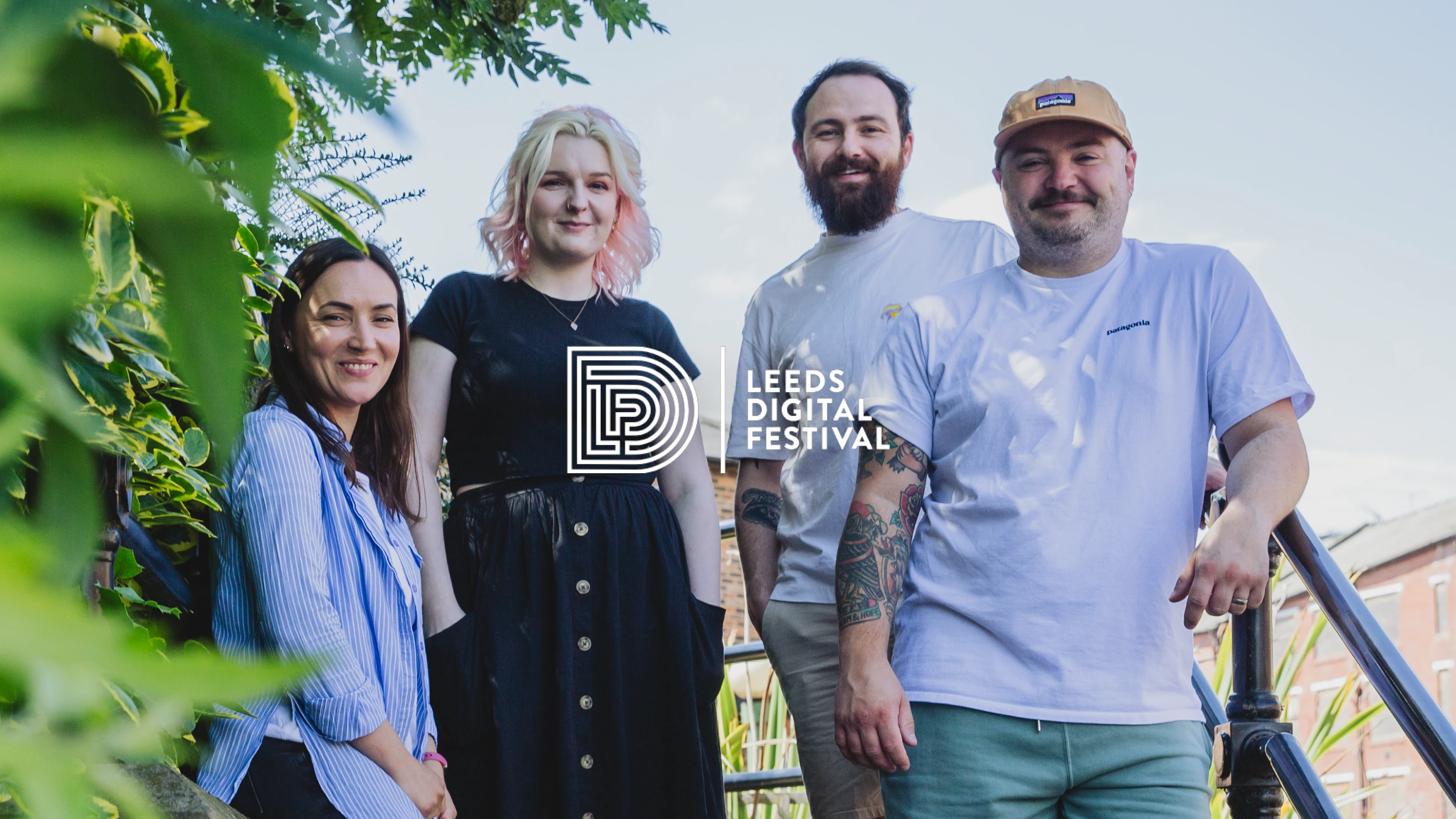 Cristina, Cat, Tom and Col are stood on some stairs outside the office on a sunny day smiling for the camera. The Leeds Digital Festival logo is overlaid.